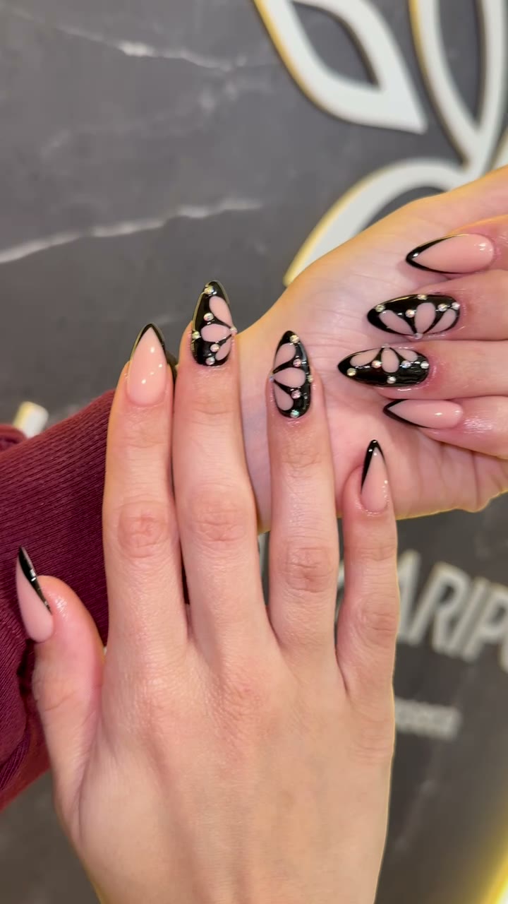 Uñas con mariposas negras sobre el muro del estudio